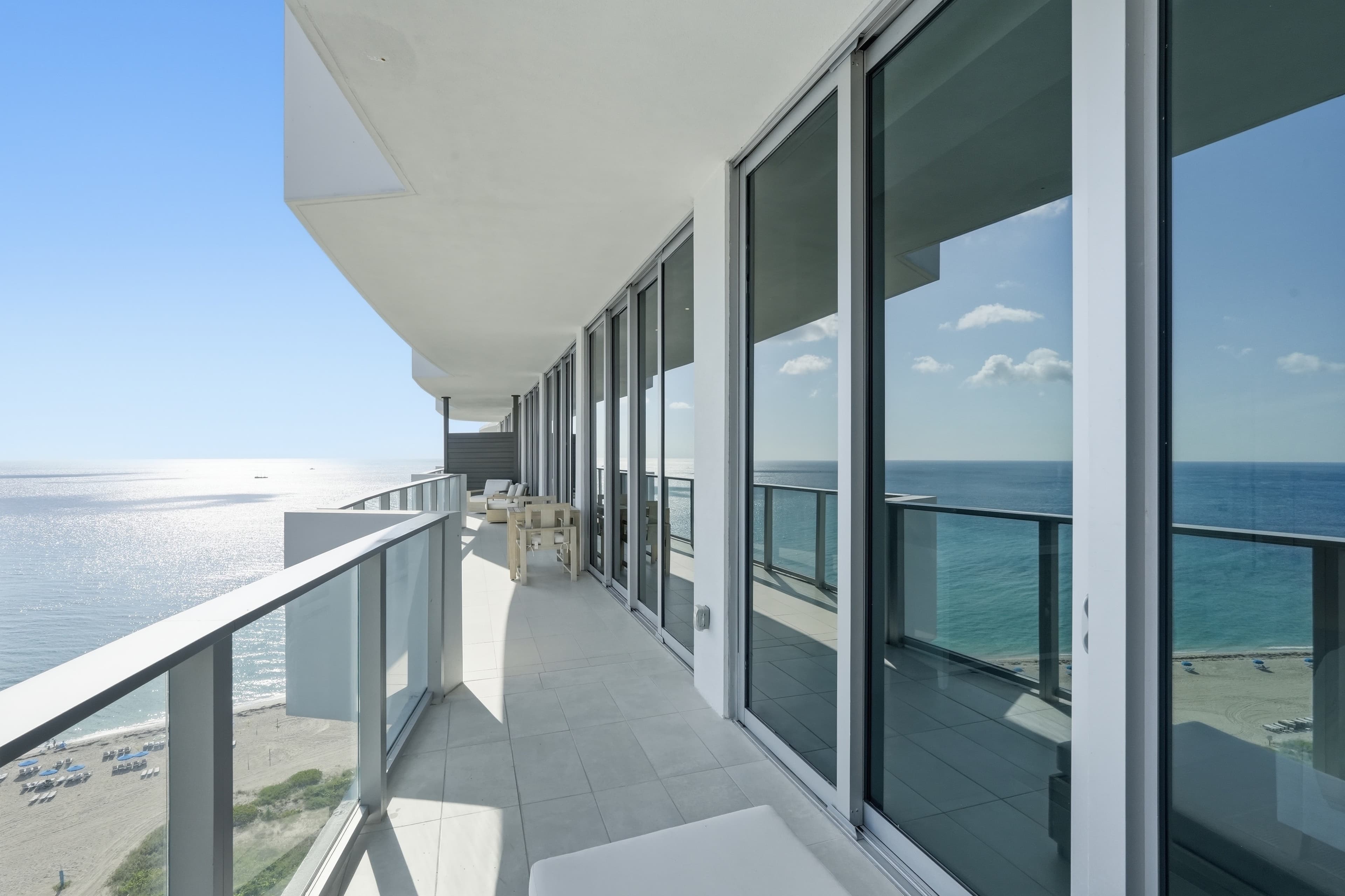 Oceanfront balcony with glass railing and sliding doors