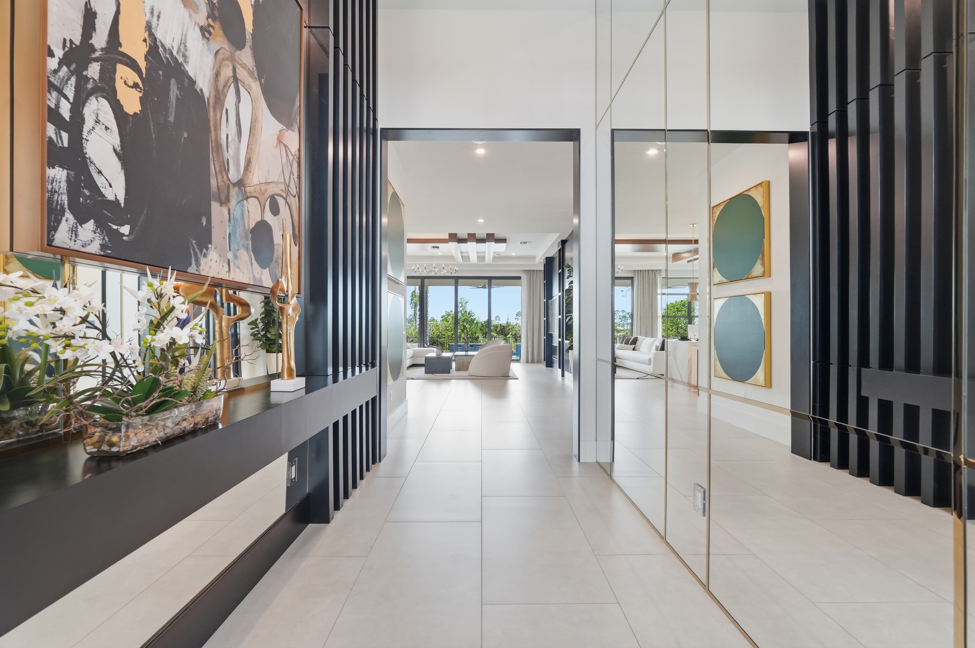 Hallway with black slat wall, mirrors, and view into a bright living room