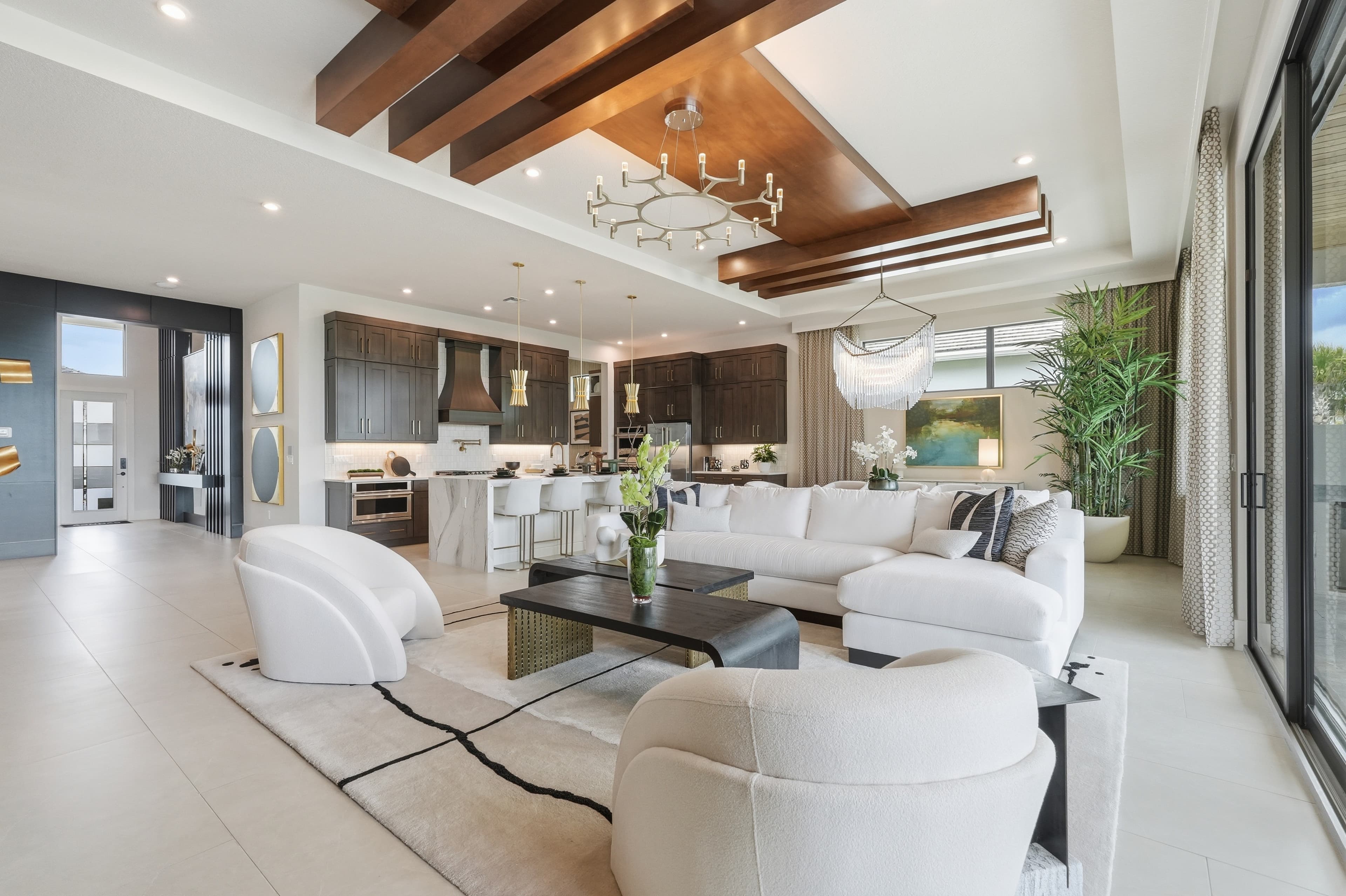 Open living room and dark-wood kitchen with white sectional and island