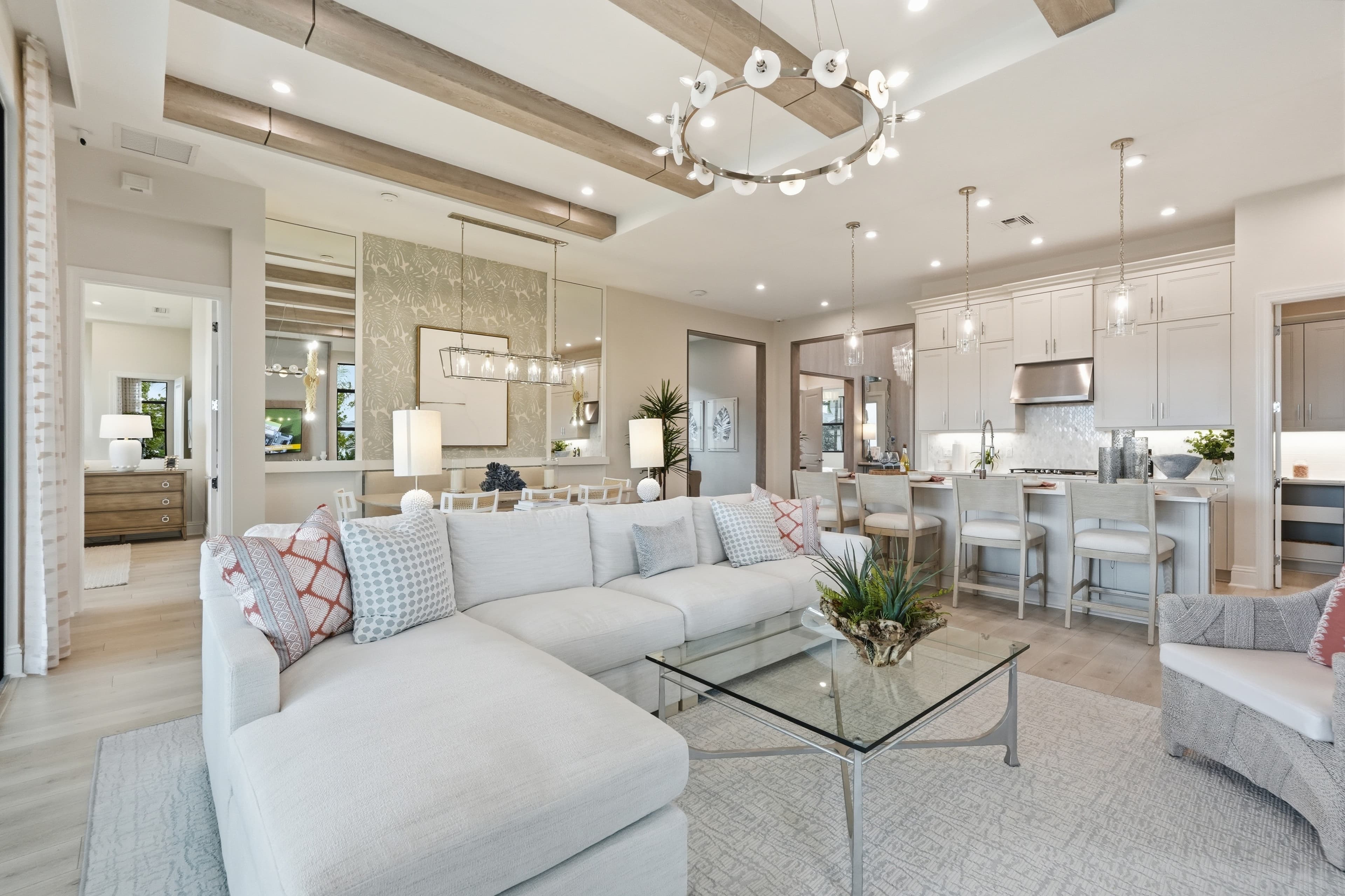Open living, dining, and kitchen with sectional and wood ceiling beams